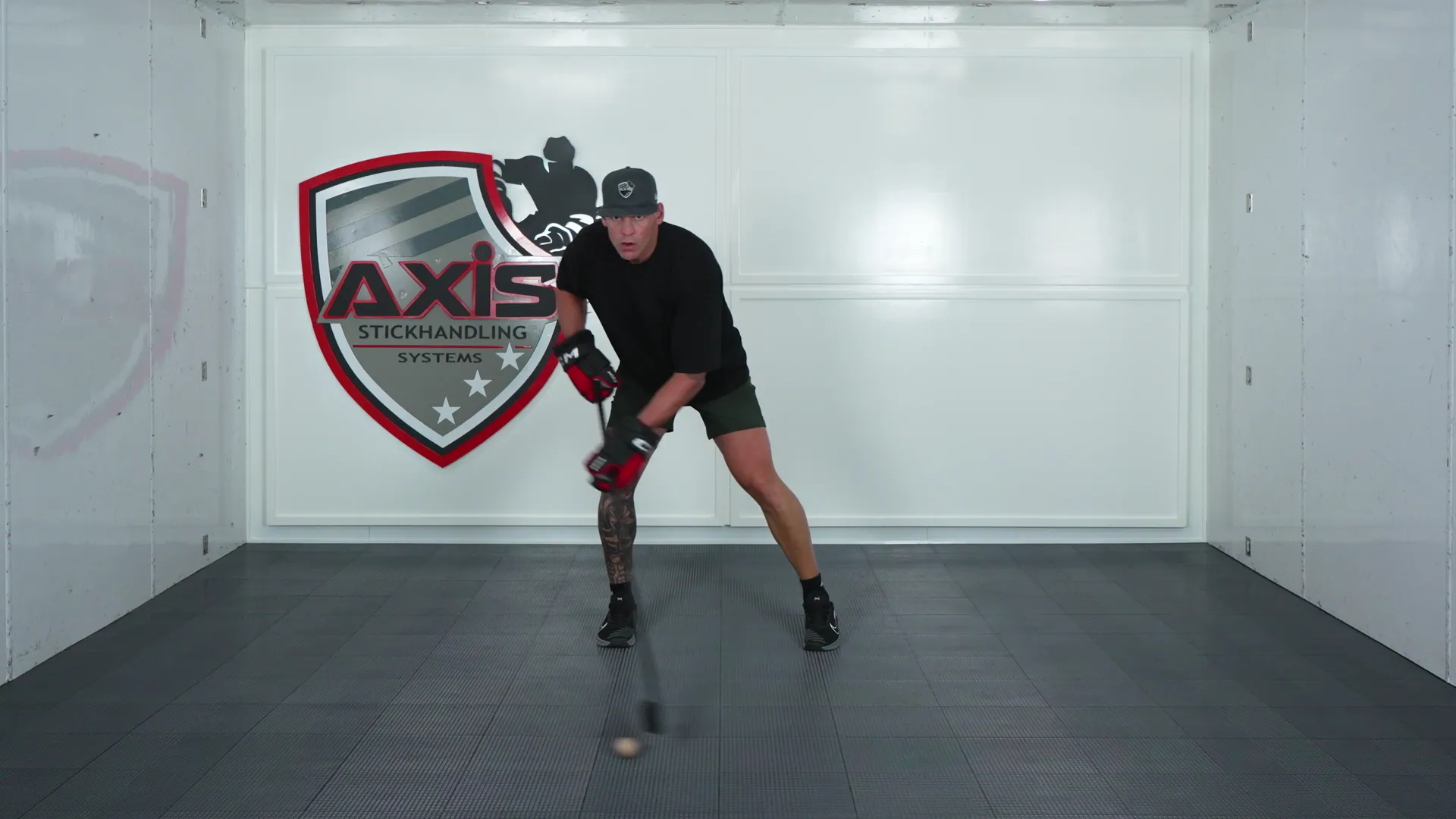 A coach stickhandling a ball from a wide reach back in front of the feet