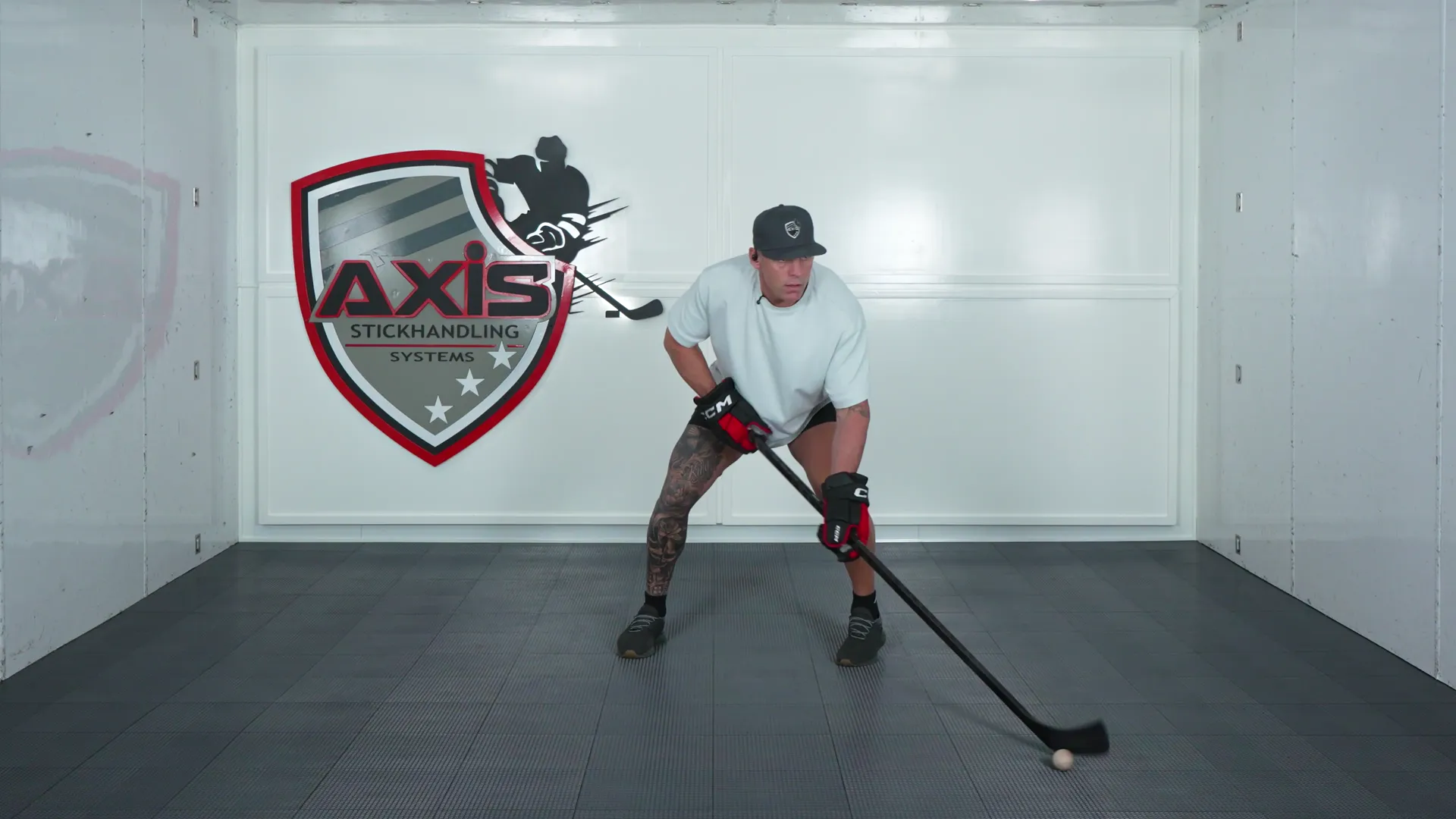 A coach stickhandling a ball side to side in a wide stance